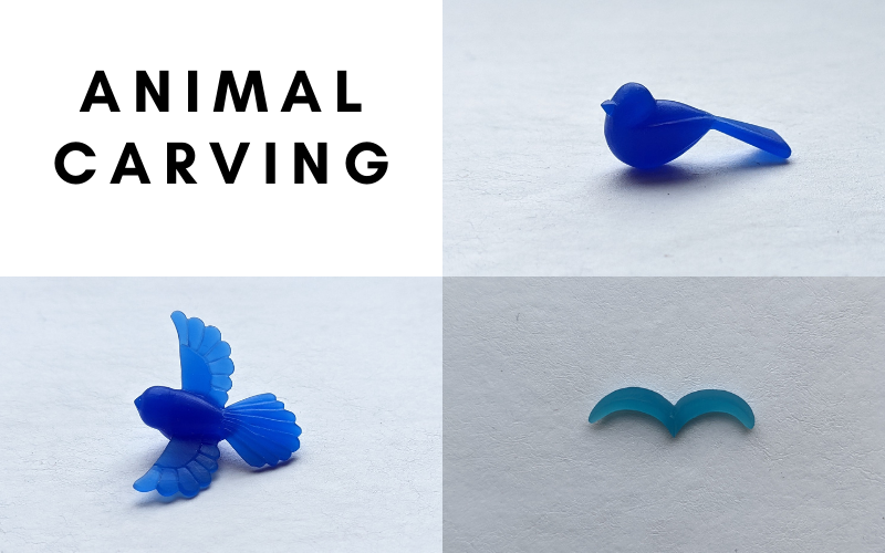 Animal carving: a chubby bird, a flying bird outline and a more detailed bird with open wings made from wax 