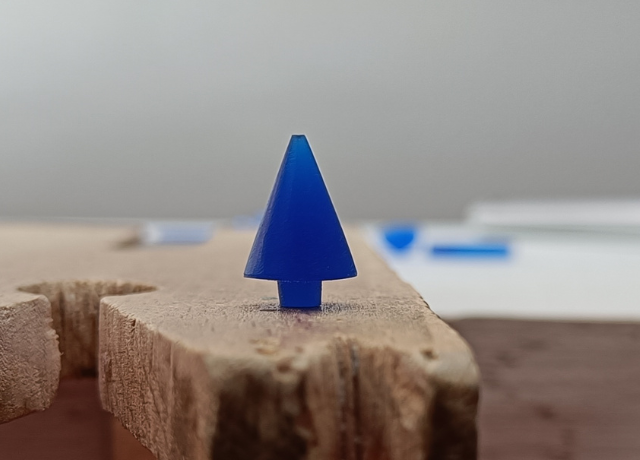Close up of a bench peg with a simple christmas tree from blue wax