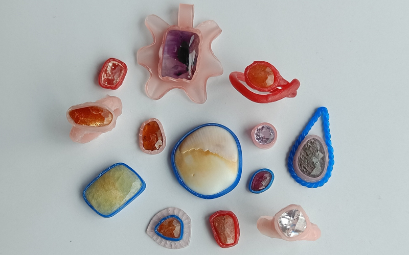 Variety of bezel pieces made from pink sheet wax, blue wire wax, and red mold a wax. All kinds of different stone colors and shapes included