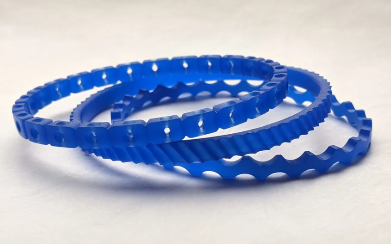 3 bangles from blue wax. Top one has holes drilled through, middle one has a burred texture and bottom one is wavy.