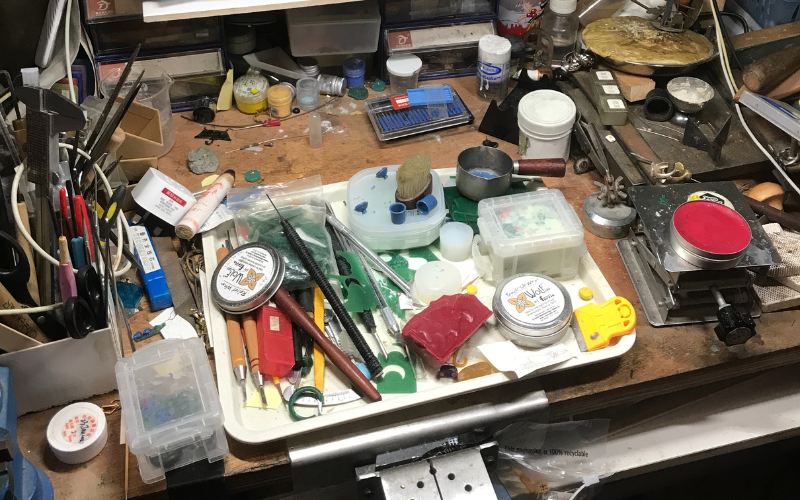 Close up photo of a bench top with all kinds of wax and tools out