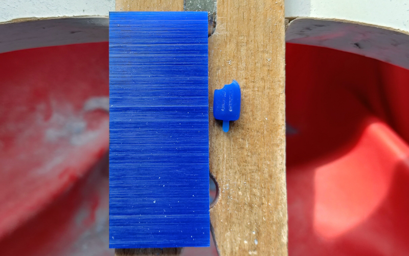 Close up of bench peg with a slice of blue wax next to an ice cream charm in blue wax of similar thickness