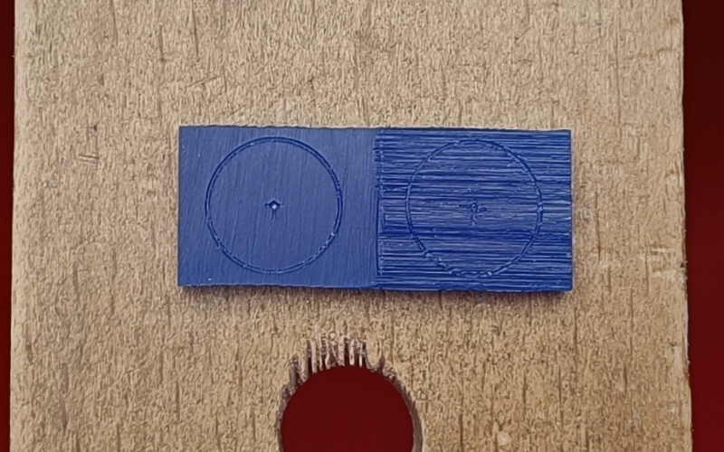 piece of wax with one side filed clean and a circle marked. The other side is unfiled and has a circle marked on it as well. The circle on teh filed side is easier to see