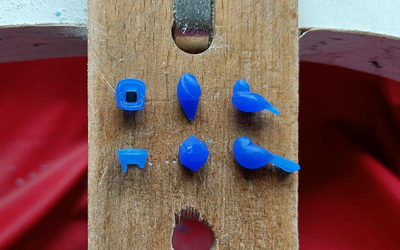 Close up of bench peg with 6 pieces from blue wax that have varying degrees of imperfections