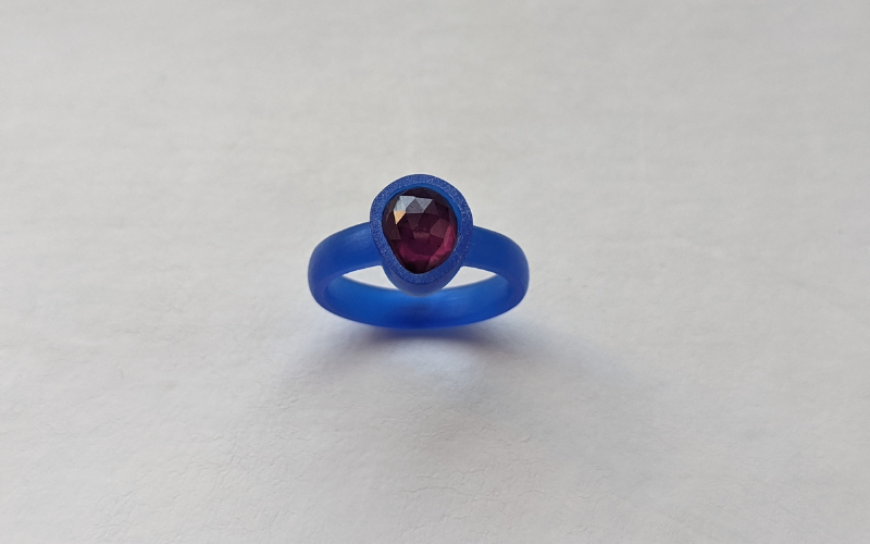 Court shaped ring from blue wax with a reddish irregularly shaped rosecut stone
