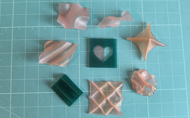 Cutting mat with an assortment of small trial pieces made from pink and green wax