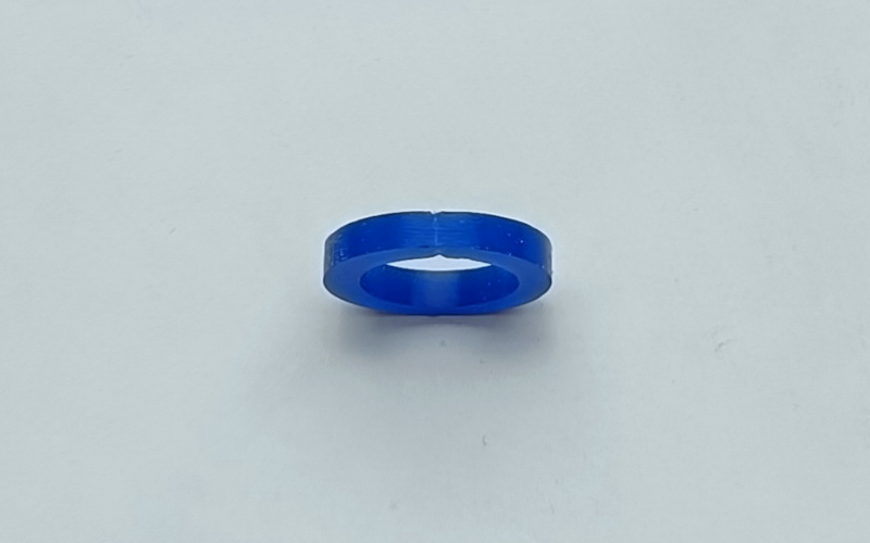 Close up of a blue wax ring that's been melted together. The melted area has been filed back and you can see clearly it's dented and thinner than the surrounding.