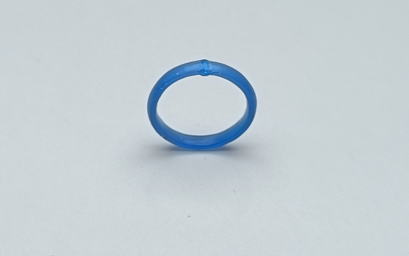 Close up of a blue wax ring with wax melted on top of a break, the added wax has been filed back to almost flush with the surface.
