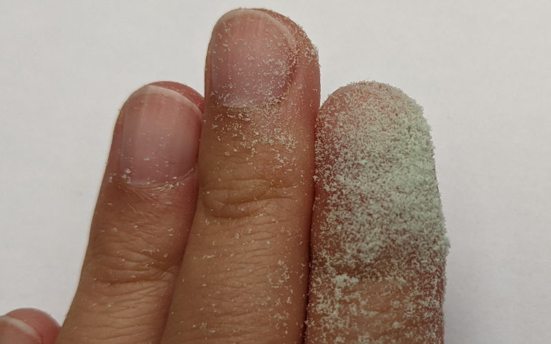 Fingers covered in super fine green wax dust