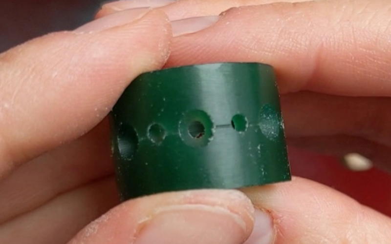 Hands marking the second part of a pattern on a green wax ring after the centre has been burred already. 