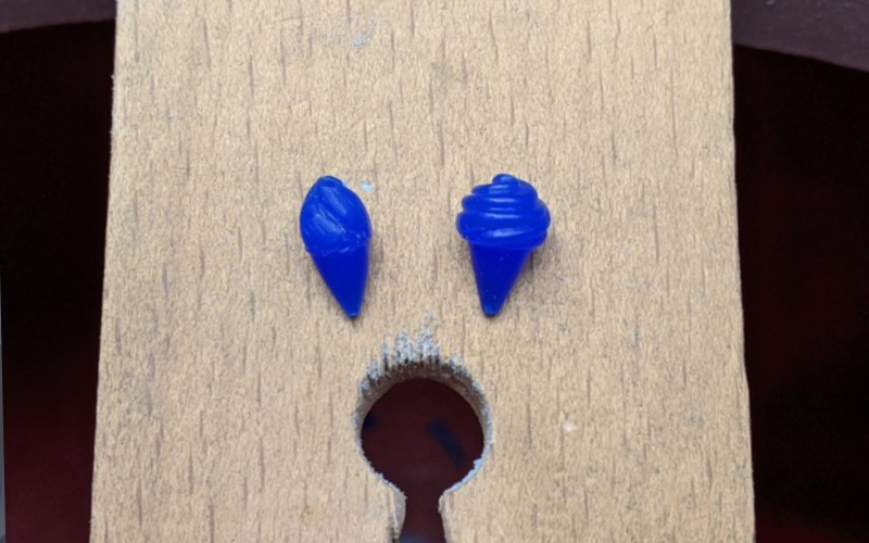 Close up of 2 ice cream charms from blue wax on bench peg. Left first version, right second improved version