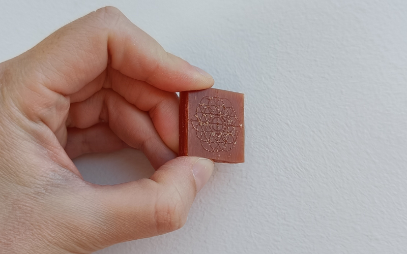 Orange wax with pattern marked on it with loads of dust still on the edges