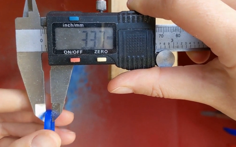 Hands measuring the width of a ring with a pair of callipers