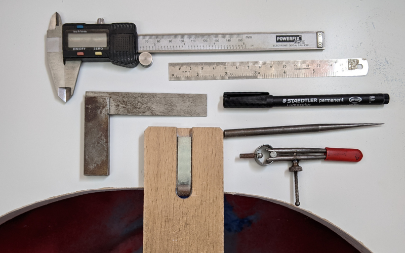 Tools for measuring and marking. Callipers, set square, scribe, ruler, dividers and permanent marker.