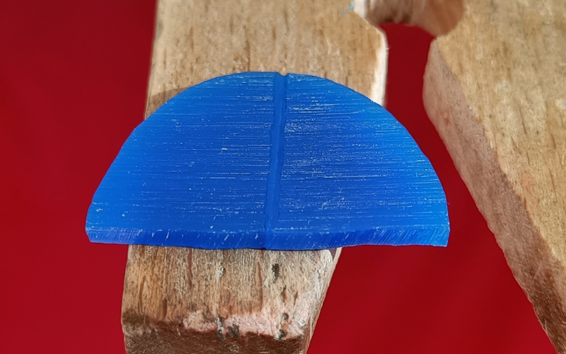 Close up of blue piece of wax that's melted together. The join is a dip through the centre