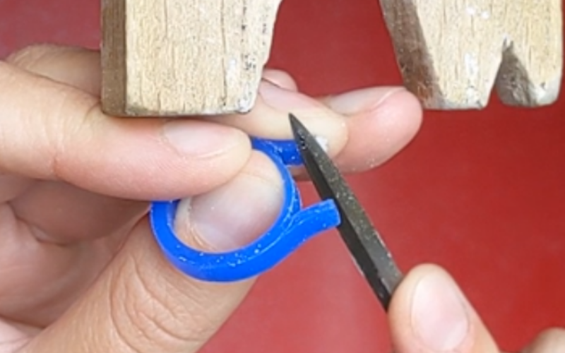 hand holding a ring with the middle finger providing extra support behind a section that sticks out