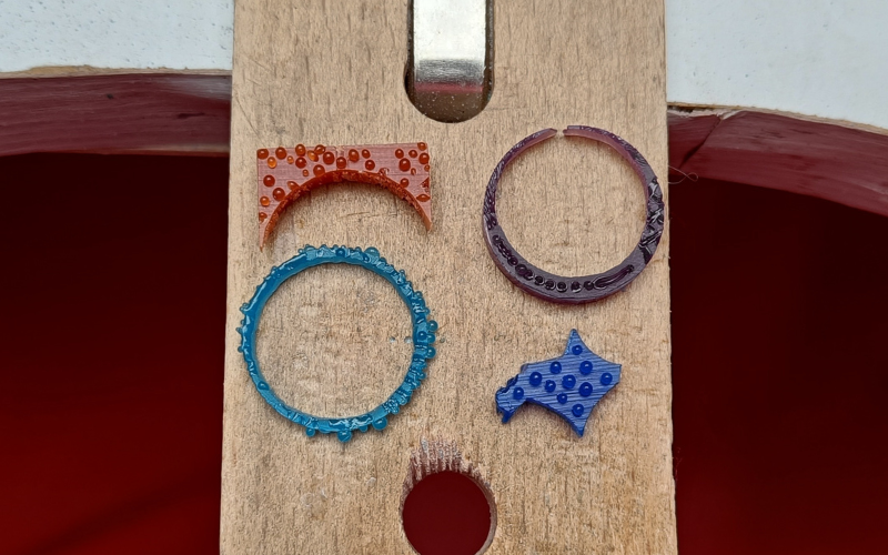 Close up of orange, purple, turquoise and blue scrap piece of wax with granulation practiced on them