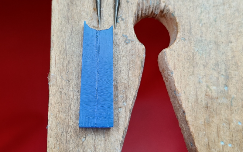 Close up of piece of blue wax with a line marked on it. The line no longer overlaps near the top. 