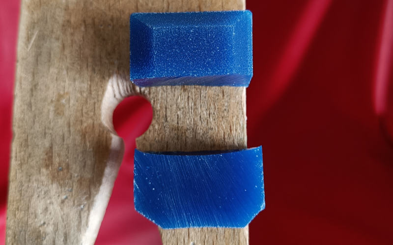 close up of pierced open block of wax. Bottom you see the cut part and it's solid with only a few airbubbles, top you see the surface with loads of airbubbles