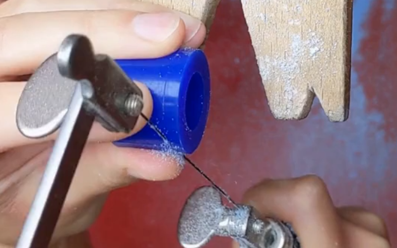 A bench peg and someone is just beginning to pierce a ring tube