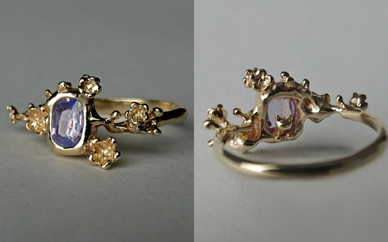 Side by side photo. Left gold ring with a blue center stone. Around the stone are small plum blossoms. Right same ring seen from the back, there's a cat hidden behind the stone