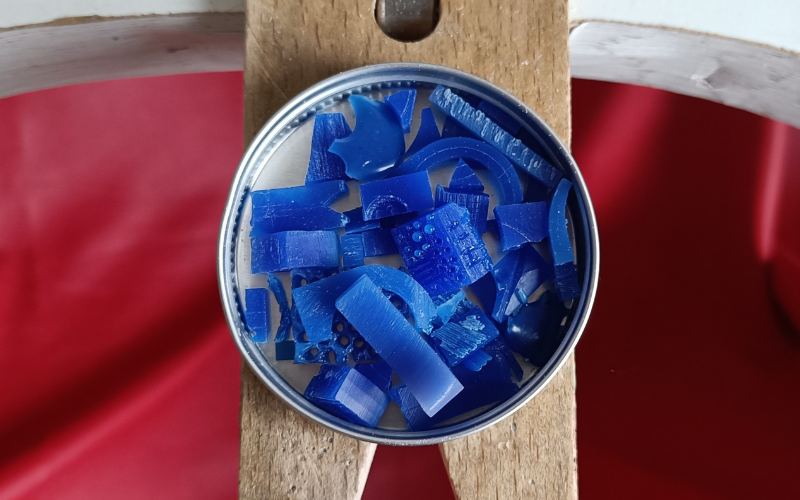Close up of small tin with scraps of blue wax