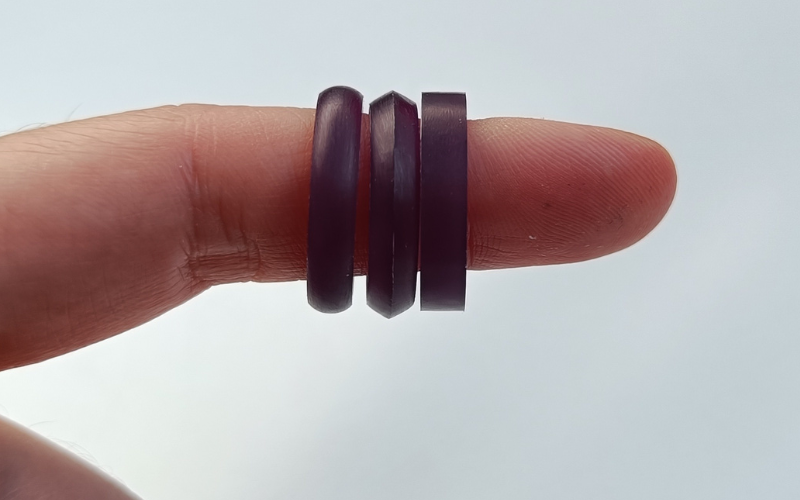 Finger with 3 wax rings out of purple wax with different ring profiles: court, knife edge and flat