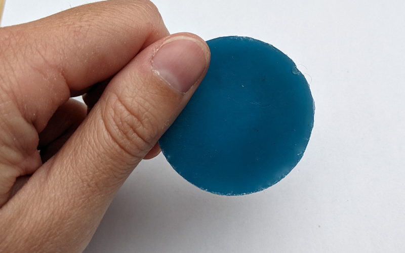 Round piece of newly melted turquoise wax. 