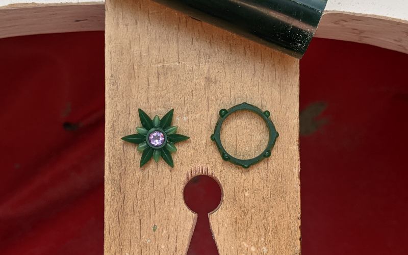 Ring and a flower shaped pendant with a central round amethyst from green wax