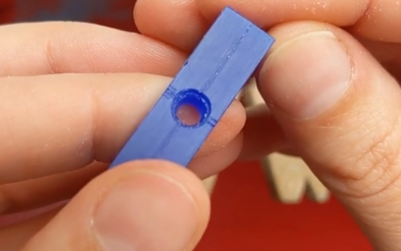 Close up of hands holding a blue wax ring with a seat cut out for a round stone.