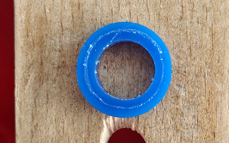 Close up of a piece of blue ring wax on a bench peg. A line has been marked over the ring and you can see that it slipped near the top with a scratch mark