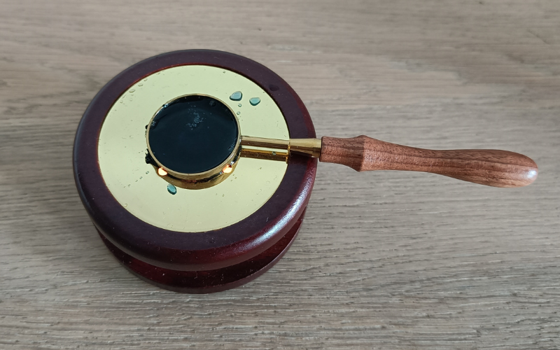 Wax seal melter, the spoon is filled with blue liquid wax