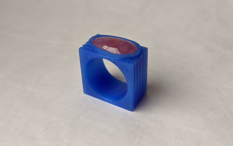 A square ring from blue wax with a pink oval stone