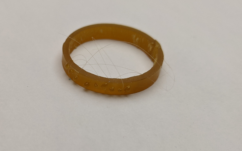 Gold wax ring with stringy blobs of wax