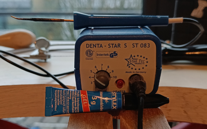 close up of bench peg with a dentastar wax heating system and a tube of superglue in front of it