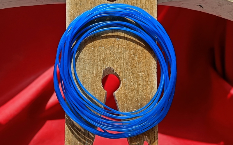 Close up of bench peg with rolled up blue wax wire on top 